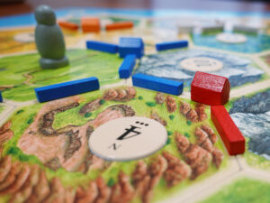 Settlers of Catan game setup, showing resource hexes and game pieces on the board of a classic Euro game
