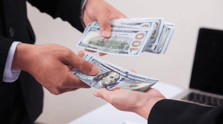 Hand giving cash to other hand